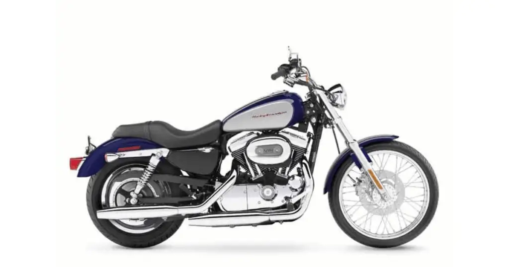 A Harley Davidson Sportster XL1200C from 2009. It's blue, white, and accented with chrome. It's used to show one of the more problematic model years