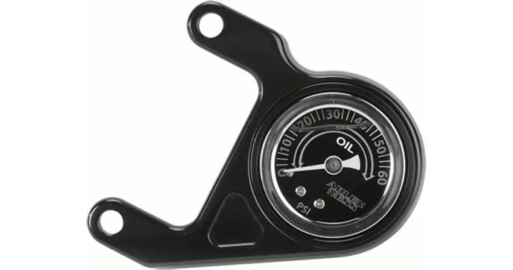 A black Harley oil pressure gauge that has been damaged