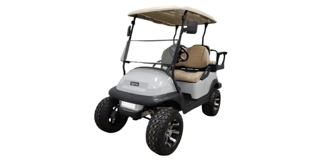 A white Club Car precedent that's lifted with custom wheels, custom tan seats, and a short tan roof